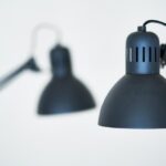 Stijlvolle zwarte metalen luminaire boven een moderne eettafel in een industrieel interieur.